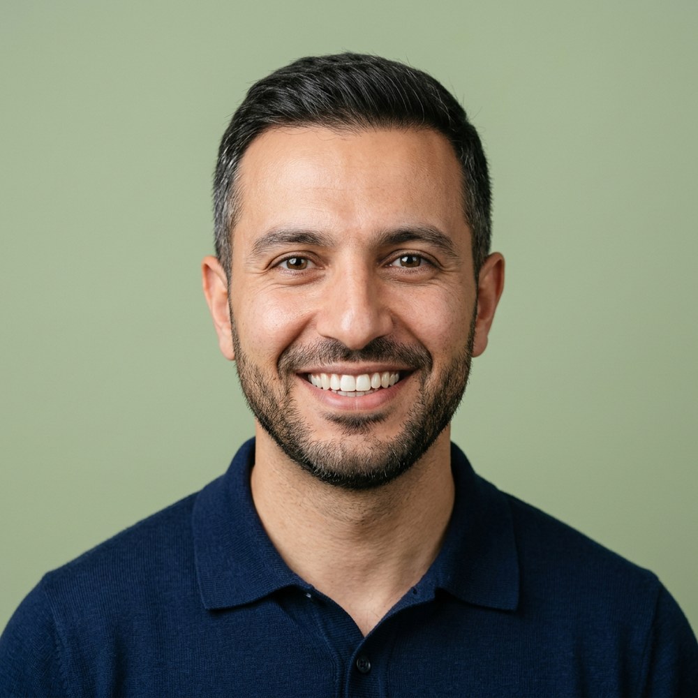 A smiling man in a navy polo