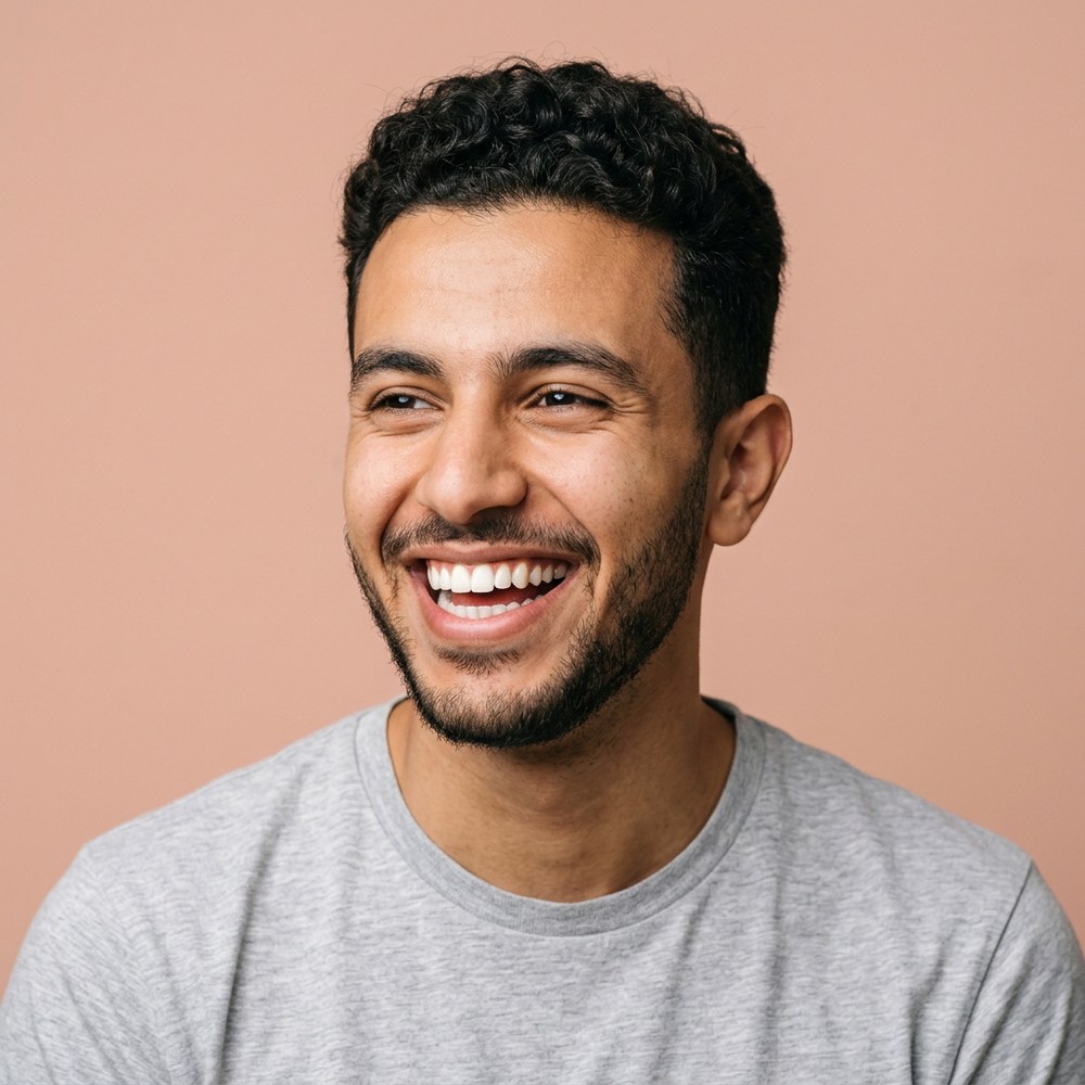A young man laughing in a grey t-shirt