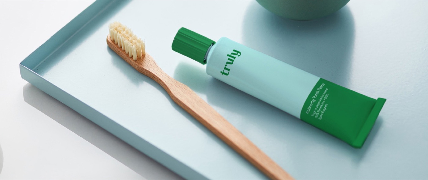 A wooden toothbrush and Truly toothpaste