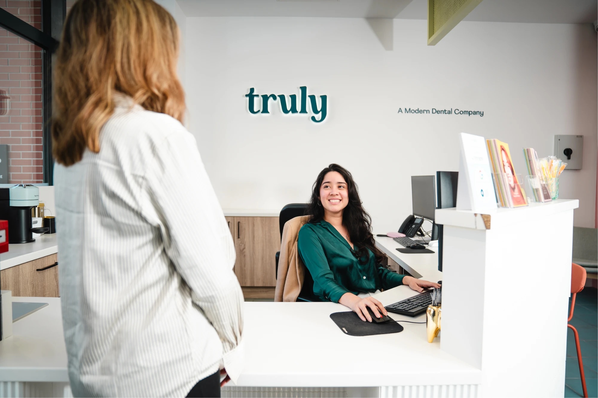 A Truly coordinator smiling at a patient at the front desk