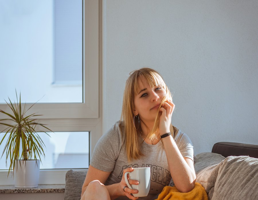 A woman resting at home with a cup of tea